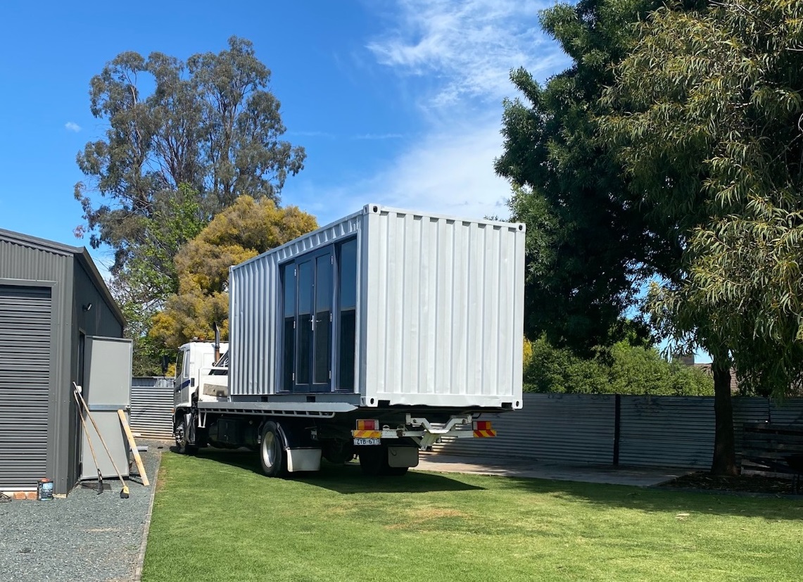 Tilt tray delivering a container to customer